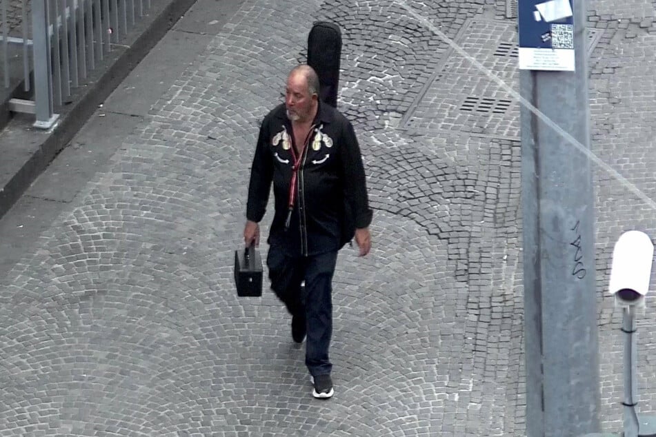 Der flüchtige Täter trug eine auffällige Gitarren-Tasche auf seinem Rücken und hielt eine Musikbox in der Hand.