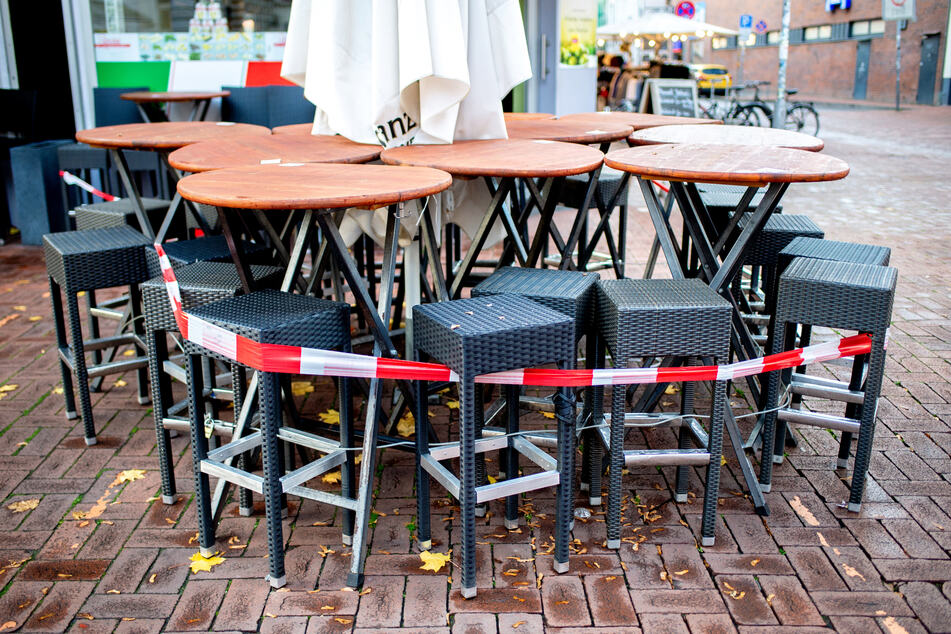 Tische und Stühle stehen vor einer Pizzeria auf der Lister Meile, die derzeit nur Speisen zum Mitnehmen anbieten kann.