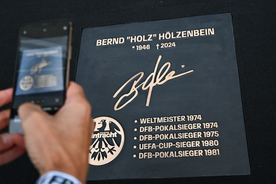 Bronzetafeln, wie hier zu Ehren von Eintracht-Legende Bernd Hölzenbein (†78), werden demnächst die Haupttribüne des Deutsche Bank Parks zieren.