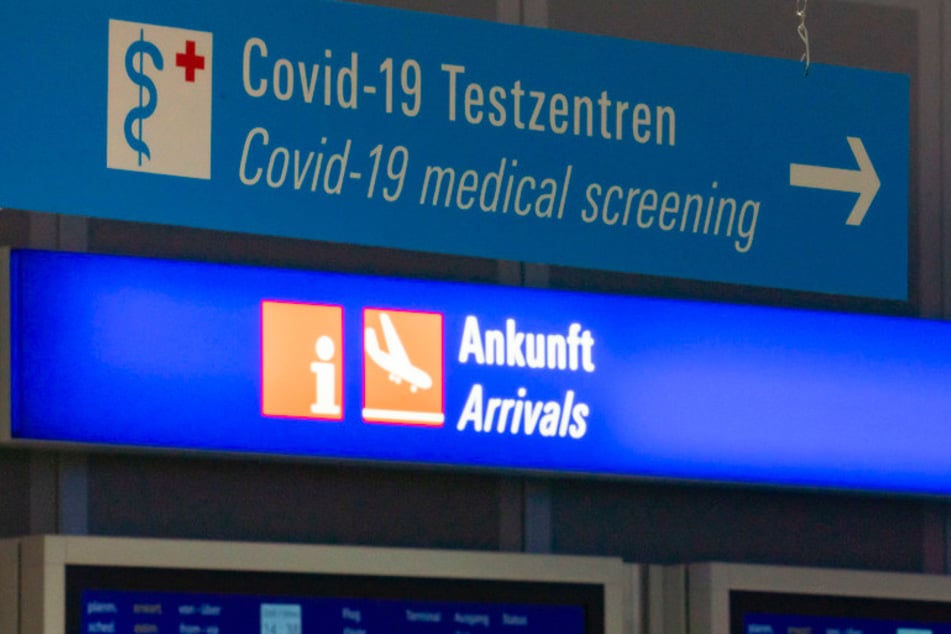 Ein Schild weist am Flughafen im Ankunftsbereich zum Covid-19-Testzentrum.