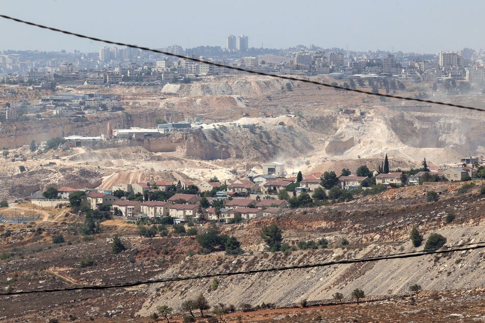 This picture taken from the village of Burqah, east of Ramallah in the illegally occupied West Bank, shows the Israeli settlement of Kokhav Yaakov with the Palestinian village of Kafr Aqab and Jerusalem in the background.