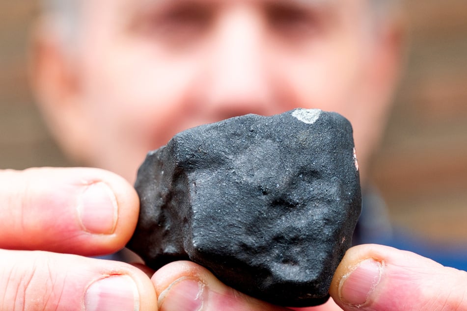 Wilfried Labusch, Hausbesitzer, zeigt den kleinen Meteoriten, der sein Haus traf.