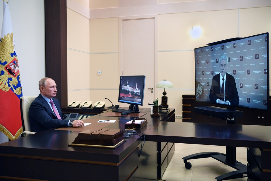 Wladimir Putin, Präsident von Russland, sitzt in der Residenz Nowo-Ogarjowo an seinem Schreibtisch und nimmt an einer Telefonkonferenz mit dem Moskauer Bürgermeister Sergej Sobjanin teil.