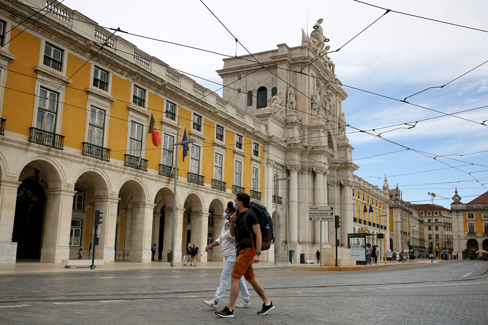 Portugal, Lissabon: Menschen mit Mund-Nasen-Schutz spazieren in der Innenstadt von Lissabon.