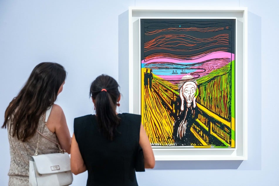 Zwei Besucherinnen studieren in der Ausstellung "Edvard Munch. Angst" das Werk "The Scream (after Munch)", 1984, von Andy Warhol.