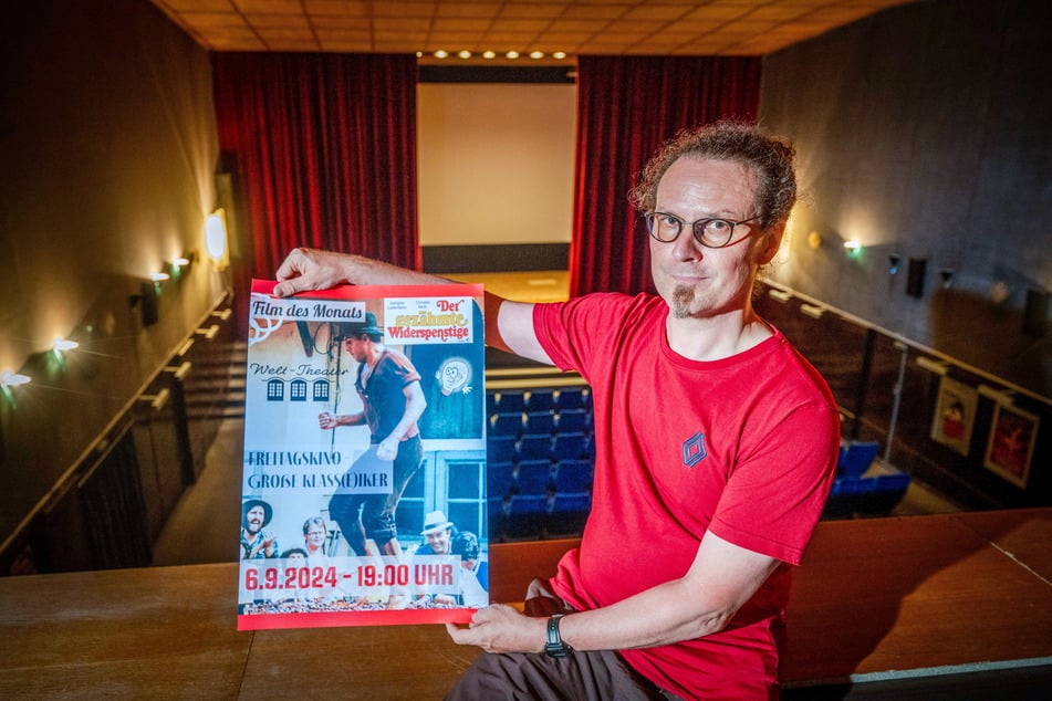 Im historischen Kinosaal von Frankenberg zeigt Burkhard Werner (51) das Plakat für die nächste Vorstellung.