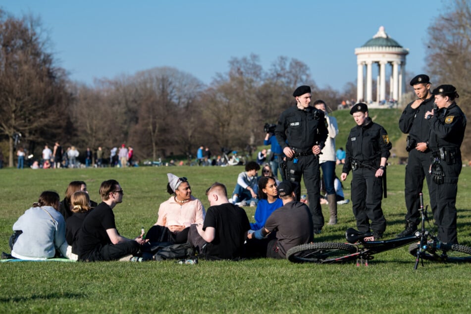 Polizisten reden im Englischen Garten mit einer Gruppe Jugendlicher. (Symbolbild)