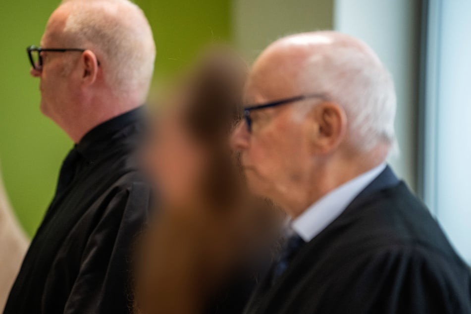 2024 wurde die Frau – hier mit ihren beiden Anwälten im Gerichtssaal – wegen unterlassener Hilfeleistung und Brandstiftung zu zwei Jahren und vier Monaten verurteilt.