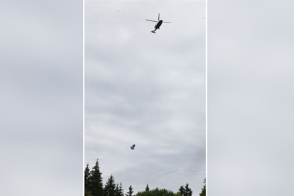 Der Hubschrauber fliegt mit der Mess-Sonde über das West-Erzgebirge.
