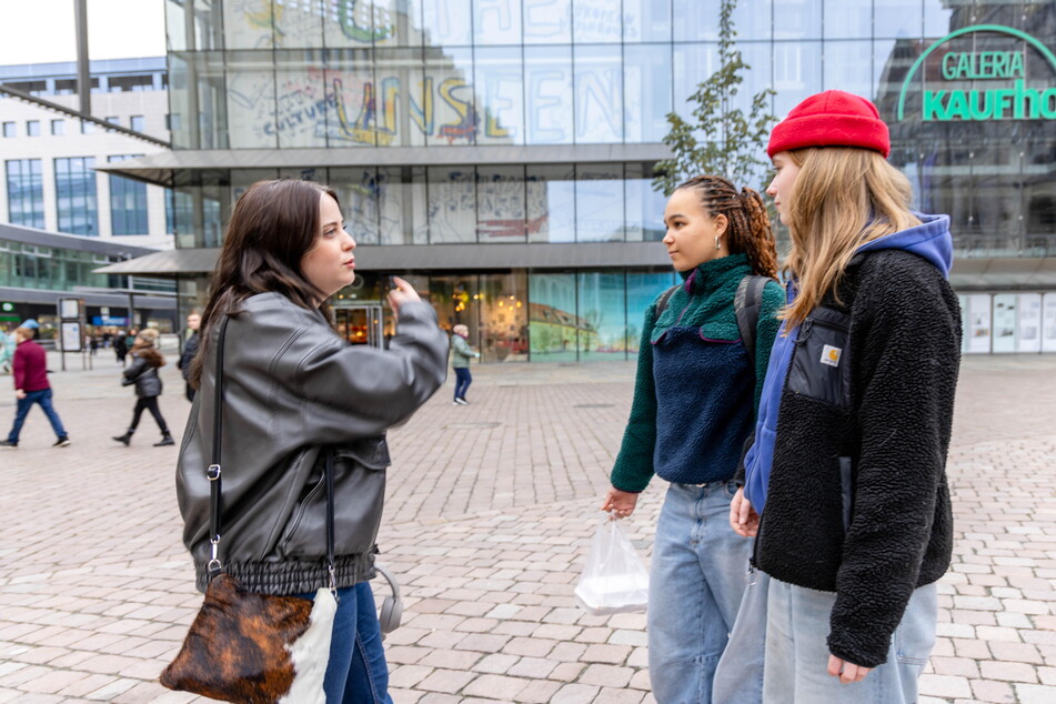 Künstlerin "Uller" (l.) erklärt den Schülerinnen Flo (16) und Lotte (16), wie das Kunstwerk entstanden ist.