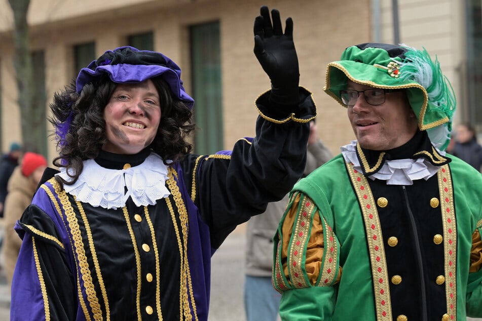 Der Helfer des Sinterklaas, "Zwarte Piet" (Schwarzer Peter), winkt beim Einzug in das Holländische Viertel.