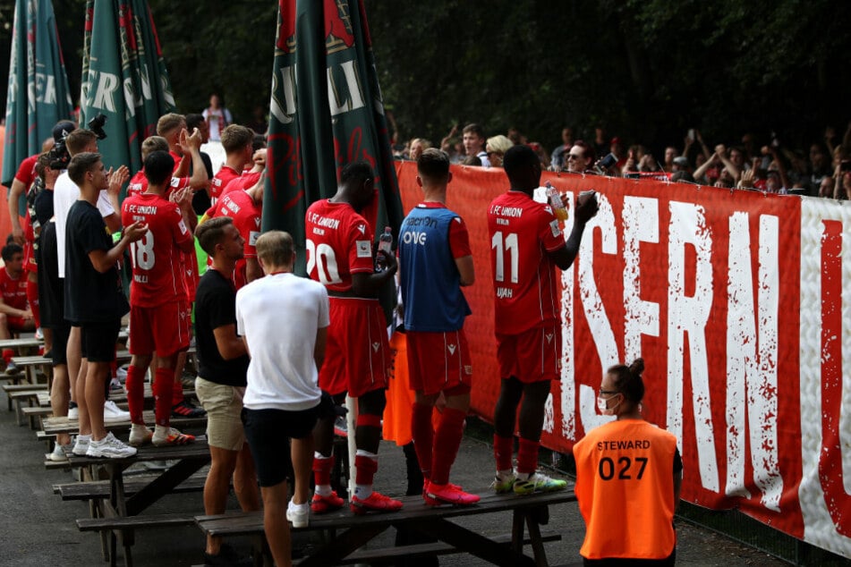 Die Spieler von Union Berlin feiern nach dem Spiel mit den Fans vor Ort.