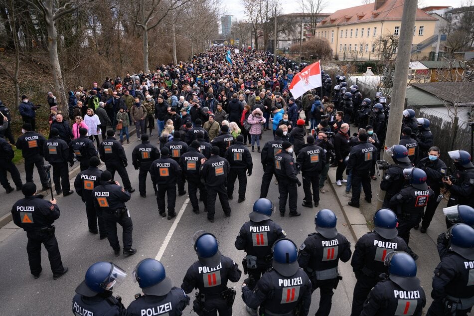 Polizisten und Demonstranten stehen auf der Magdeburger Straße.