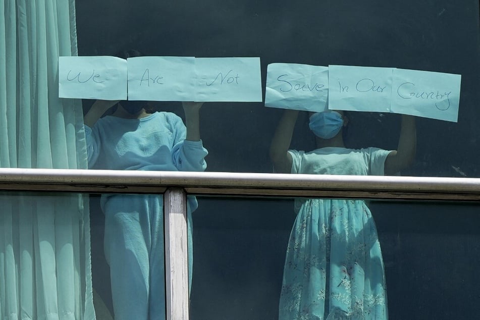 Migrants deported from the US hold up signs reading "We Are Not Safe In Our Country" at the Decapolis Hotel in Panama City on February 18, 2024.