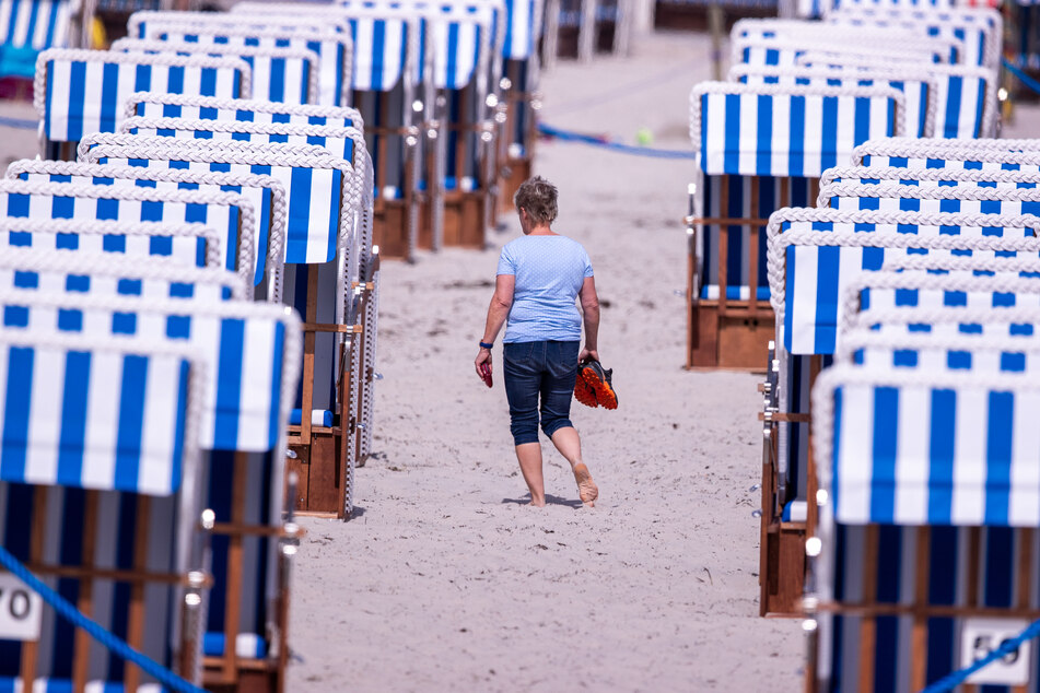 Gäste sind am Ostseestrand von Boltenhagen unterwegs. Auch hier entfällt ab jetzt die Testpflicht nach der Einreise.