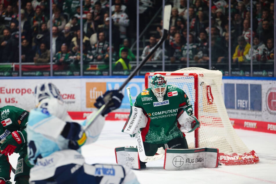 Eislöwe Andrew Yogan (v.) nagelt hier die Scheibe an der linken Schulter von Augsburgs Goalie Michael Garteig (beide 34) vorbei ins Tor.