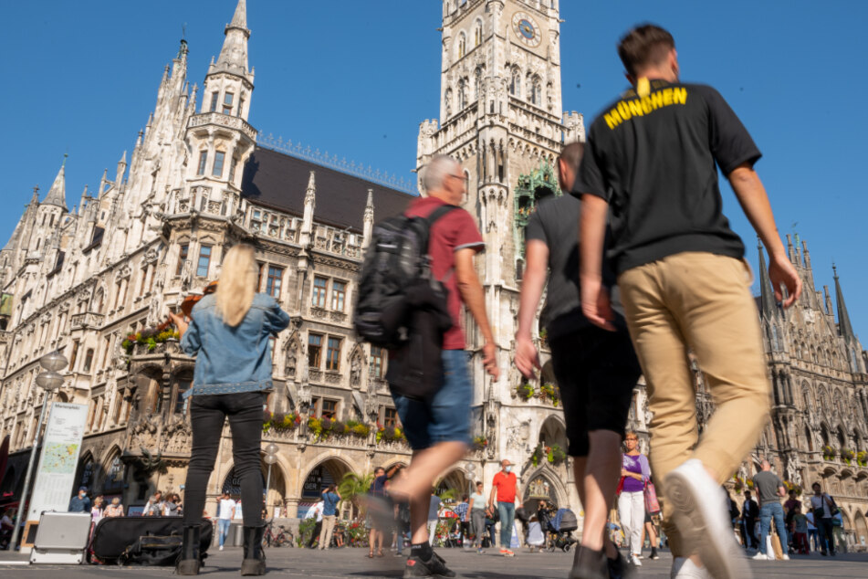 Passanten schlendern über den Marienplatz im Herzen der bayerischen Landeshauptstadt. Im Hintergrund ist das Rathaus zu sehen.