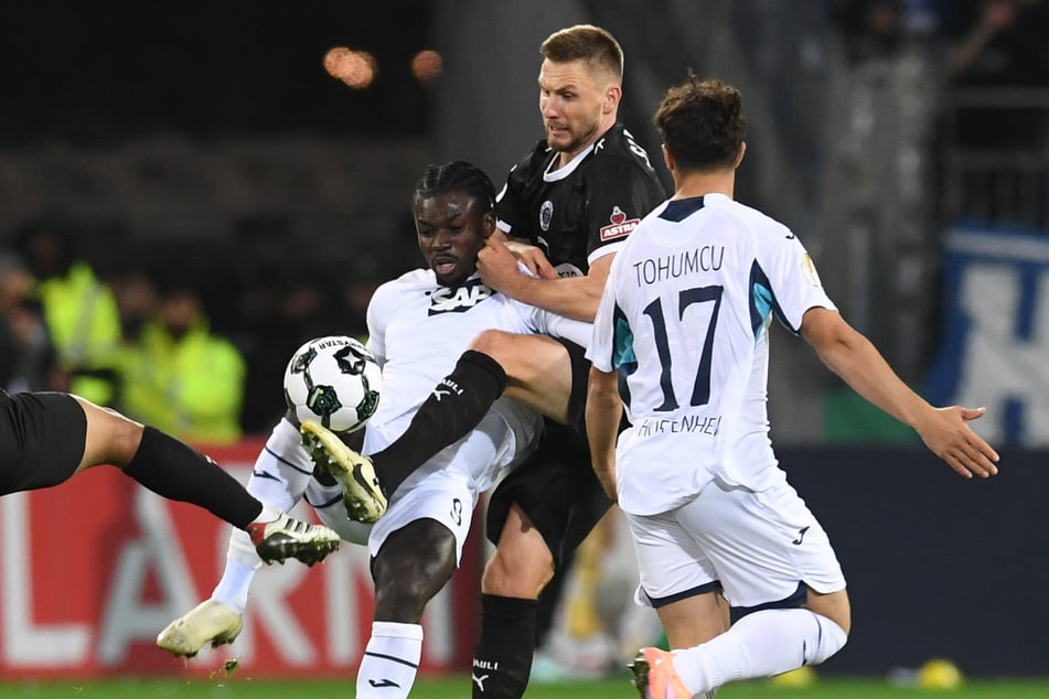 Voller Einsatz! Hoffenheims Ihlas Bebou (31, v.l.n.r.), Paulis Karol Mets (32) und TSG-Akteur Umut Tohumcu (21) kämpfen um den Ball.