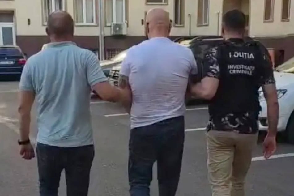 Ein zweiter Beschuldigter wird von den Einsatzkräften der rumänischen Polizei abgeführt.