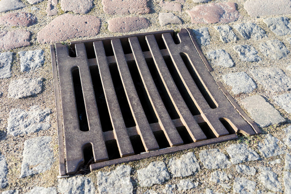 Eine Frau wollte ihren Schlüssel retten und blieb im Gullydeckel stecken. (Symbolbild)