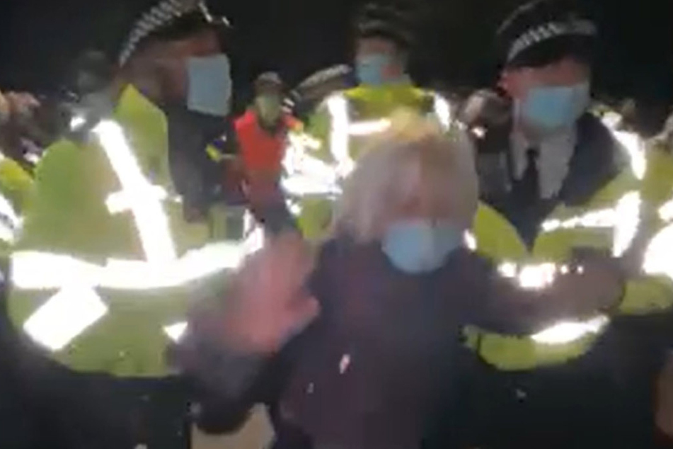 Polizisten stoßen während der Mahnwache einer Frau in den Rücken.