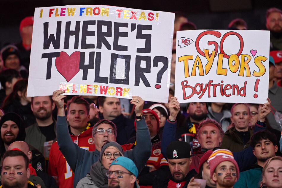 Fans hold up placards referring to Taylor Swift's boyfriend Kansas City Chiefs tight end Travis Kelce during the NFL game between Miami Dolphins and Kansas City Chiefs in Germany on November 5, 2023.