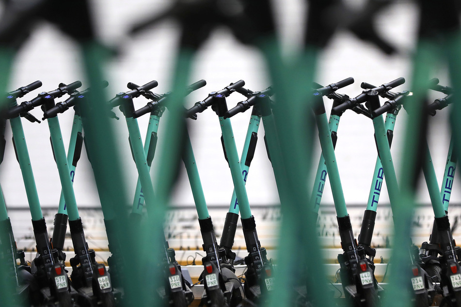 Elektrische Tretroller stehen beim E-Scooter Verleiher Tier zum Aufladen in einer Halle.