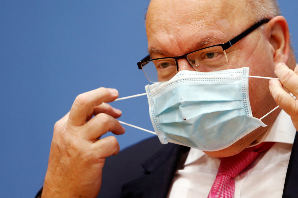 Peter Altmaier (CDU), Bundesminister für Wirtschaft und Energie, nimmt seinen Mund-Nasen-Schutz bei einer Pressekonferenz ab, um die wirtschaftliche Herbstprognose der Bundesregierung vorzulegen.