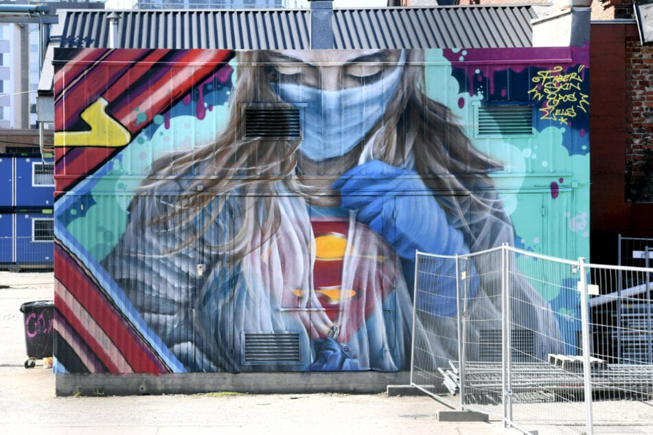 Finnland, Helsinki: Ein Wandbild zur Unterstützung und als Dank für medizinisches Personal im Kampf gegen die Corona-Pandemie, zeigt eine Ärztin mit Mundschutz im Superwoman-Kostüm.