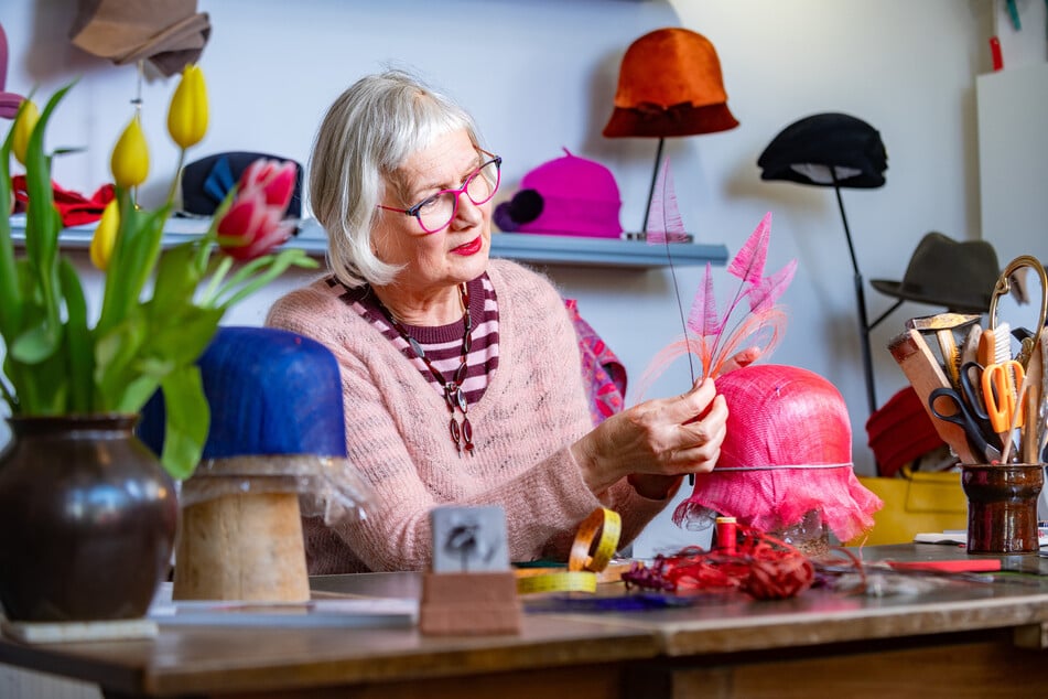 Jacqueline Peevski (64) sucht ein Arrangement von farbigen Federn für den Hut aus.