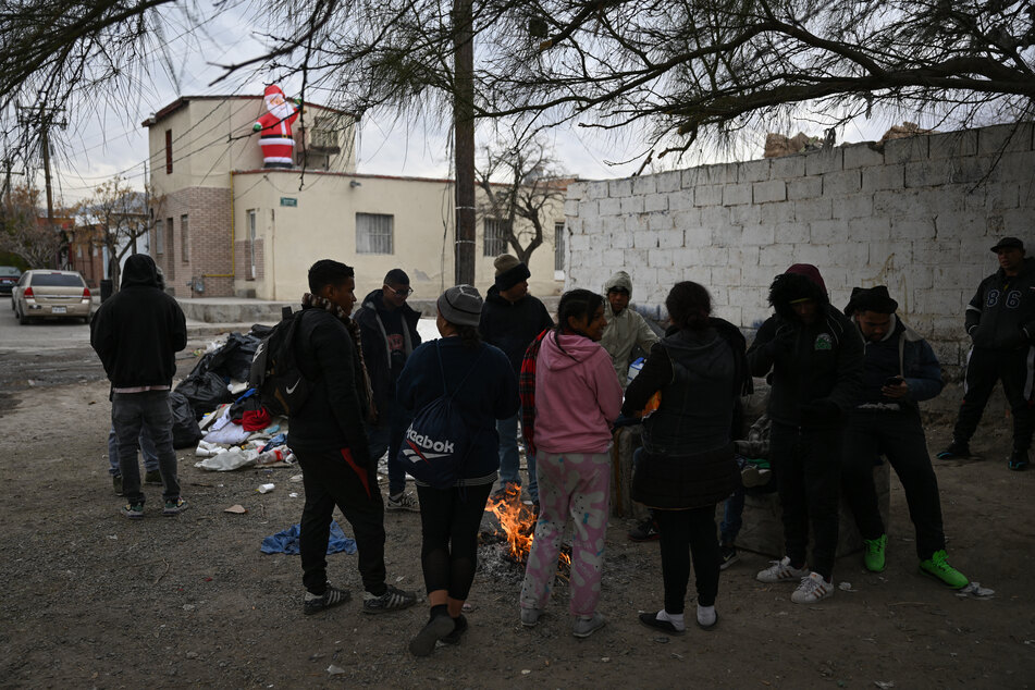 Migrants from Venezuela keep warm by a fire while waiting for Title 42 to be lifted, in the border city of Ciudad Juarez, Mexico, on December 18, 2022.