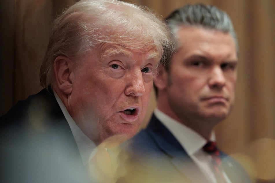 Defense Secretary Pete Hegseth (r.) looks on as President Donald Trump speaks during a meeting of his Cabinet at the White House on December 2, 2025.