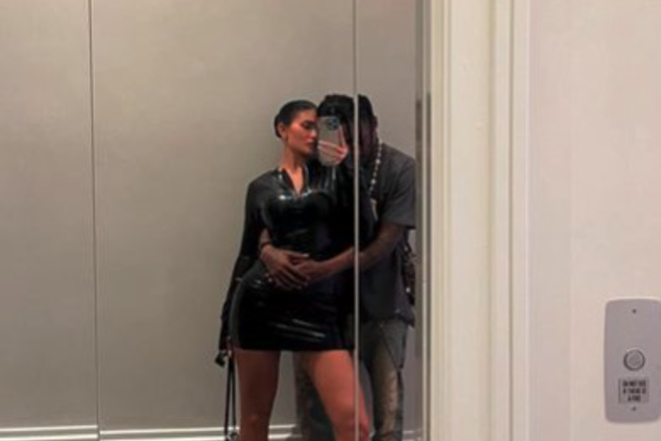 Kylie Jenner (l) strikes a pose with her partner, Travis Scott, during a date night out.