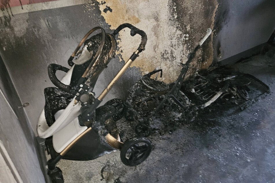 Der Kinderwagen wurde bei dem Feuer vollständig zerstört. Auch ein zweiter Wagen sowie die Hauswand wurden in Mitleidenschaft gezogen.