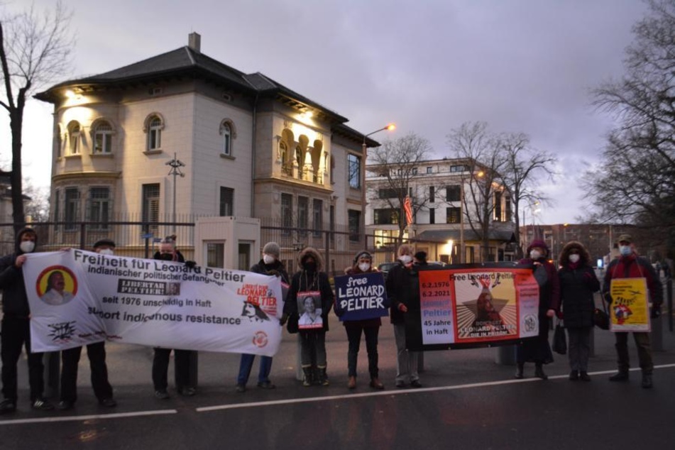 German activists hold signs and banners calling for the release of Indigenous political prisoner Leonard Peltier during a monthly vigil outside the US Consulate in Leipzig.