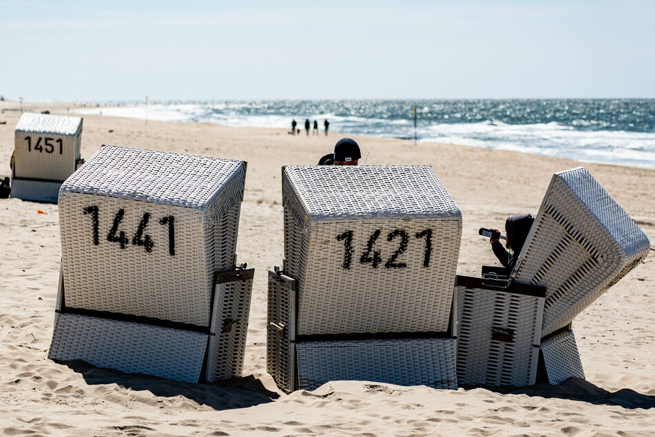 Ein Mann sitzt auf Sylt in einem Strandkorb. Nach monatelanger Corona-Unterbrechung ist der Tourismus auch hier wieder gestartet.