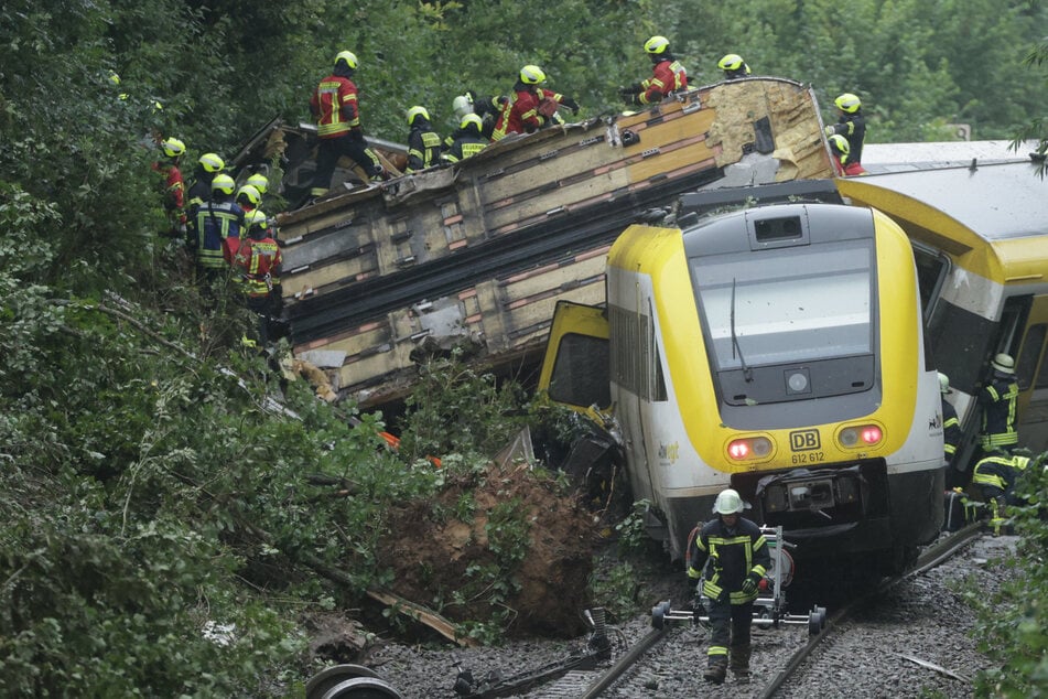 Rettungskräfte suchen den verunglückten Zug nach Fahrgästen ab.