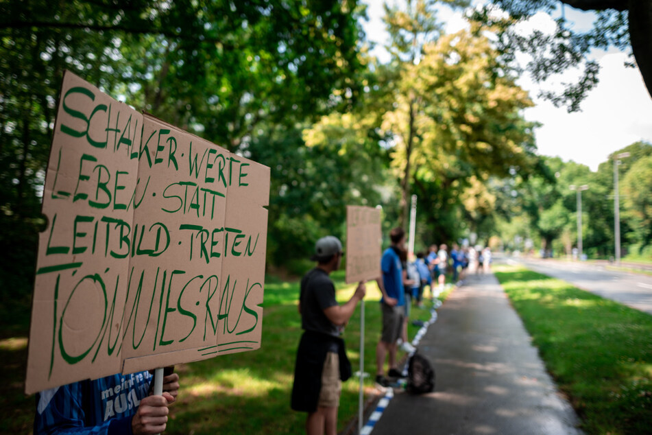 Ein Mann hält in der Menschenkette ein Schild mit der Aufschrift "Schalker Werte leben statt Leitbild treten. Tönnies raus". Zeitgleich zum letzten Saison-Spiel der Fußball-Profis des FC Schalke 04 demonstrierten Fans des Bundesligisten an der heimischen Veltins-Arena in Gelsenkirchen.