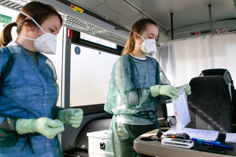 Die Ärztin Annika Hempelmann (l) und Medizinstudentin Paula Wiens verpacken in einer mobilen Abstrichstation einen Corona-Schnelltest für den Versand ins Labor. 