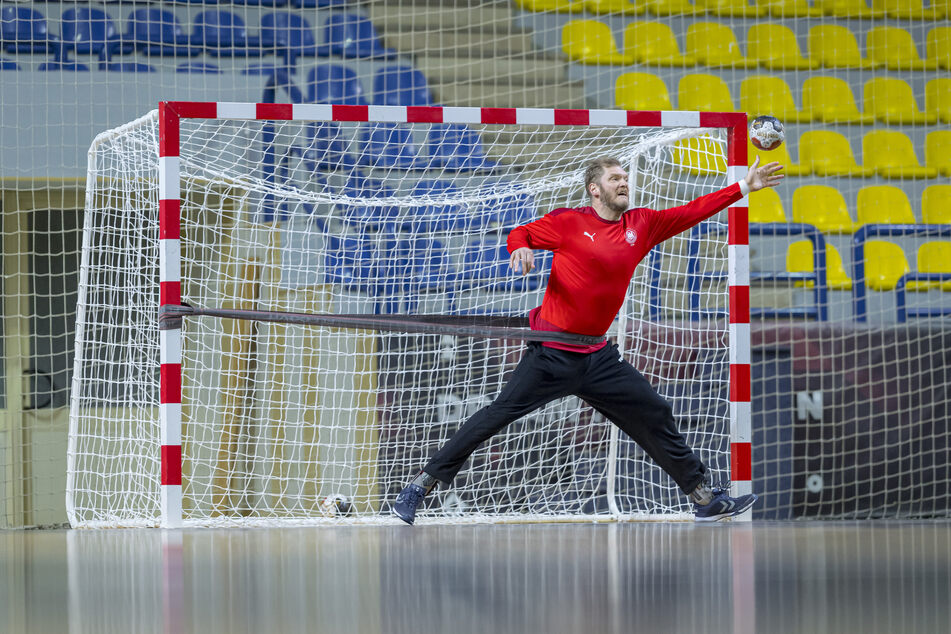 Torwart Johannes Bitter (TVB 1898 Stuttgart) trägt beim Training ein Gummiseil um die Hüften, welches an einem Torpfosten befestigt ist und pariert trotz Widerstand einen Ball.