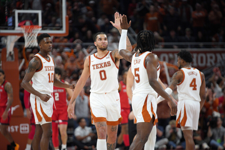 Texas Longhorns basketball players Timmy Allen (center l) and Marcus Carr (center r) high-five during a game at the Moody Center.