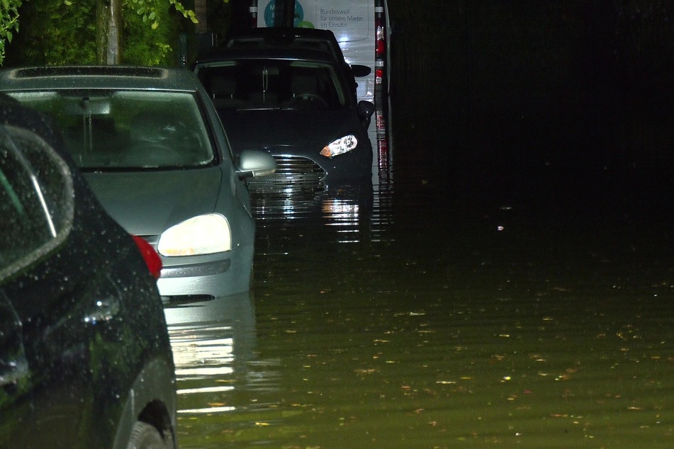 Autos stehen nach einem heftigen Regen und Gewittern auf einer überfluteten Straße am Graitenweg in Essen-Stoppenberg.