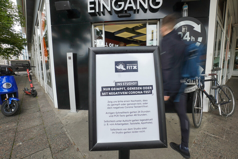 Ein Schild, das darauf hinweist, dass eines der "3Gs" (geimpft, genesen, getestet) erfüllt sein muss, steht vor einem Fitnessstudio am Alexanderplatz.