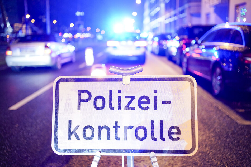 Ein Schild mit der Aufschrift "Polizeikontrolle" steht auf der Straße. (Symbolbild)