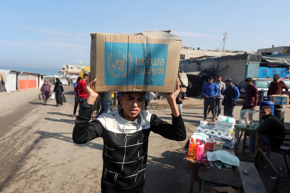 A Palestinian child carries an aid box distributed by UNRWA in Deir Al-Balah, in the central Gaza Strip, on November 4, 2024.