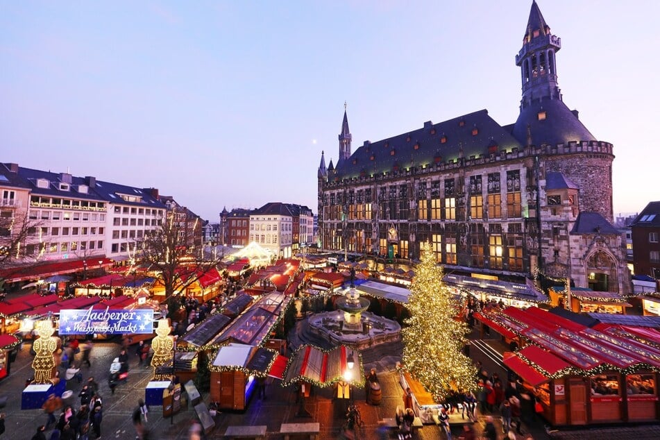Zur Weihnachtszeit umgibt der farbenfroh dekorierte Aachener Weihnachtsmarkt das Rathaus.
