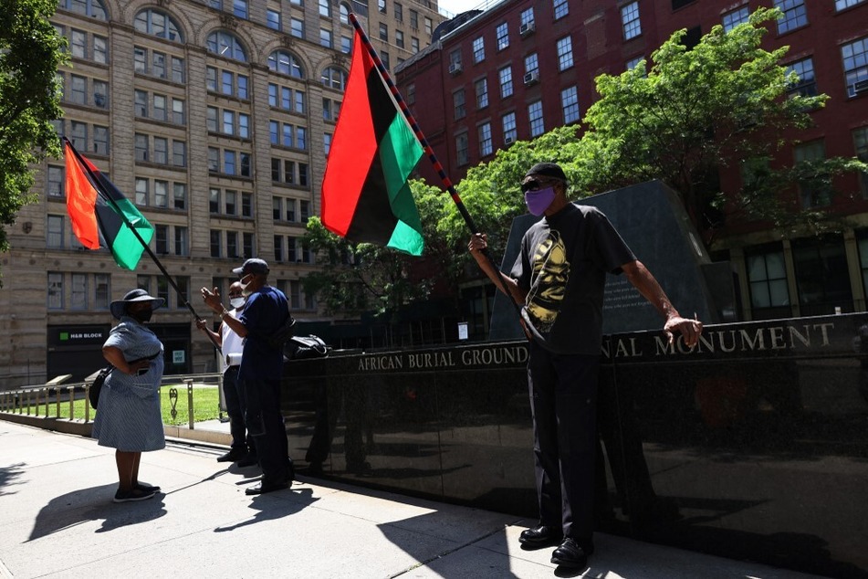 Community members await the start of a rally for reparations at the African Burial Ground National Monument in New York City.
