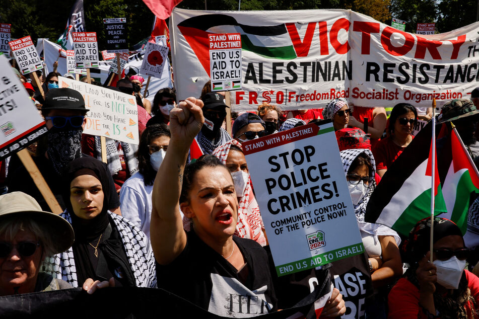 People hold signs and flags in support of Palestinian liberation and a ceasefire in Gaza during a rally on the sidelines of the Democratic National Convention in Chicago, Illinois.