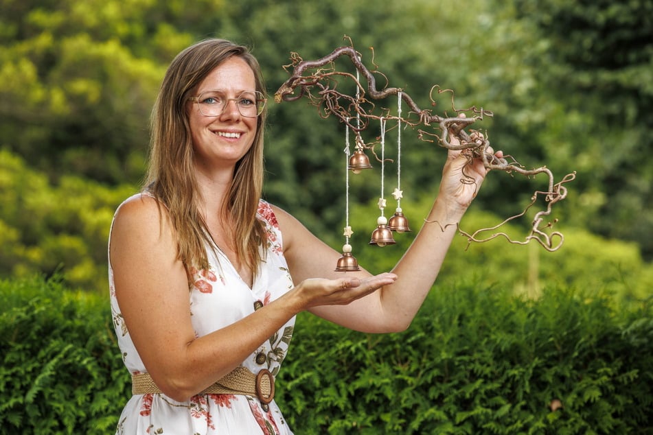 Nadine Höckendorff (37) mit einem der kleinen Glöckchen, die aus dem alten Kupferdach der Kirche hergestellt wurden.