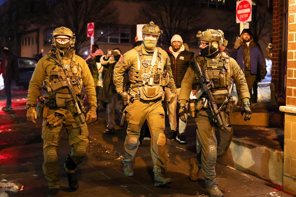 Federal agents with Homeland Security Investigations leaving a residential building after detaining a protester in Minneapolis, Minnesota, on February 5, 2026.